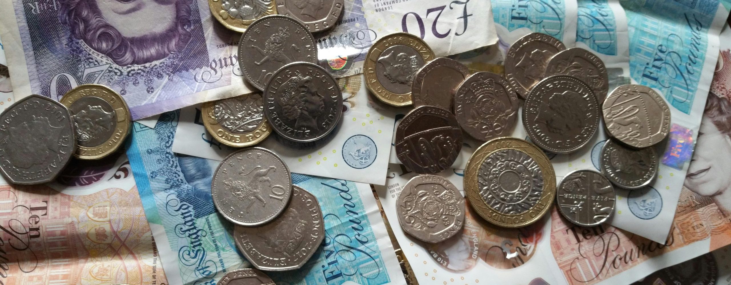 A close up of british coins and paper currency