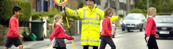 A crossing guard helping children cross the road